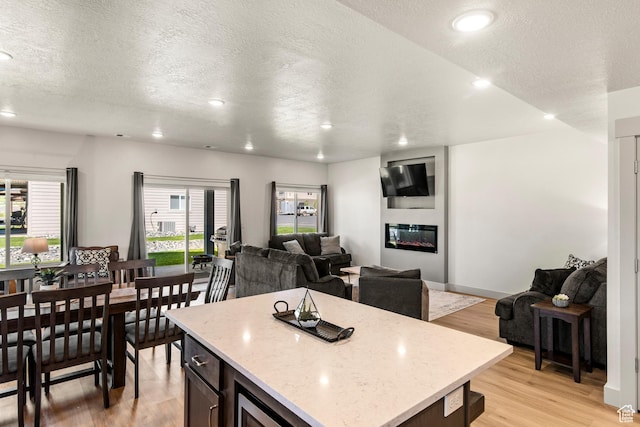 140 W 150th St S Unit D12, Garden City, UT 84028 - kitchen with light wood-style flooring, light stone counters, open floor plan, a center island, and recessed lighting