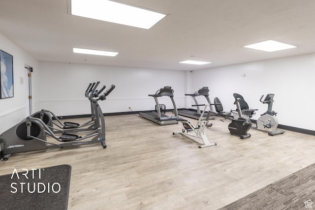 workout area featuring baseboards and wood finished floors