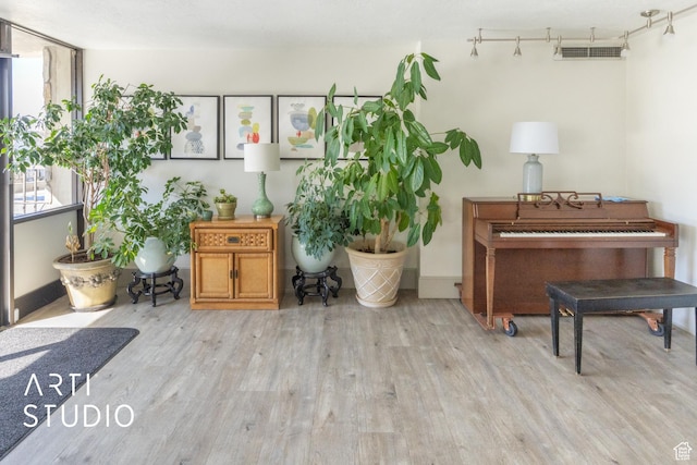 sitting room with baseboards and light wood finished floors