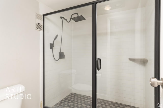 full bathroom with toilet, visible vents, and a stall shower