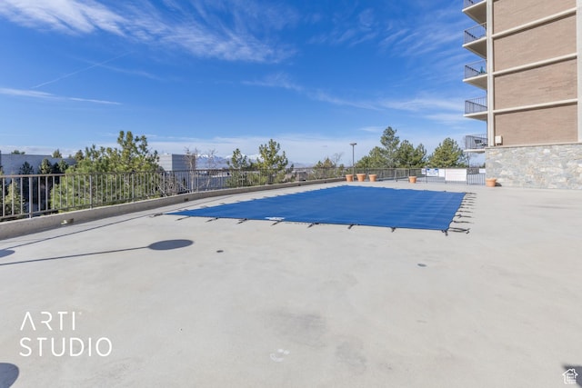 view of swimming pool featuring fence