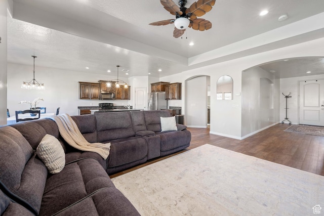 265 E Kimball Ct, Washington, UT 84780 - living room featuring recessed lighting, arched walkways, wood finished floors, and ceiling fan with notable chandelier