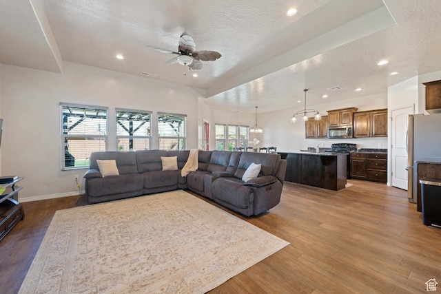 265 E Kimball Ct, Washington, UT 84780 - living room with ceiling fan with notable chandelier, a textured ceiling, a healthy amount of sunlight, and wood finished floors