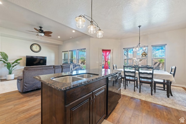 265 E Kimball Ct, Washington, UT 84780 - kitchen featuring dark stone counters, a sink, dark brown cabinetry, black dishwasher, and light wood-style floors