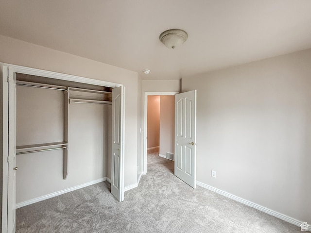 unfurnished bedroom featuring a closet, visible vents, carpet, and baseboards