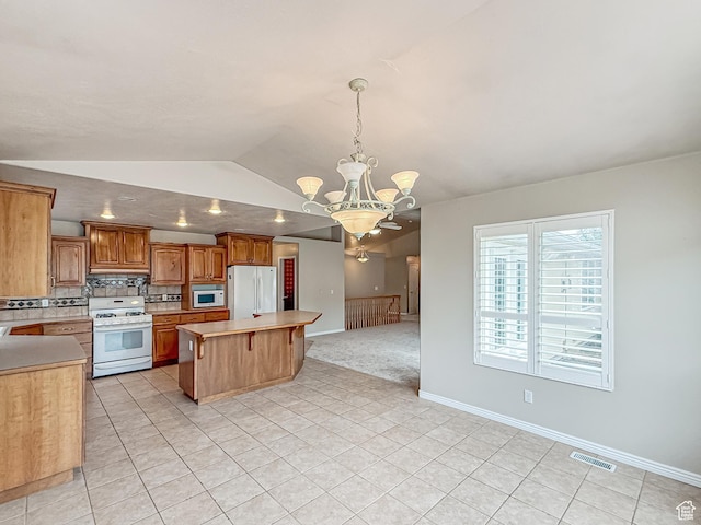 kitchen with visible vents, a notable chandelier, white appliances, light countertops, and vaulted ceiling