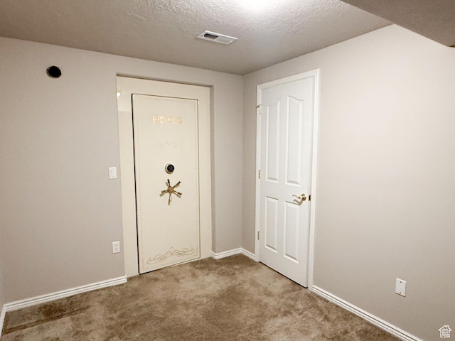 interior space featuring visible vents, a textured ceiling, and baseboards