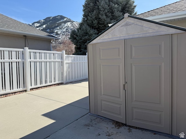 view of shed featuring a mountain view and fence
