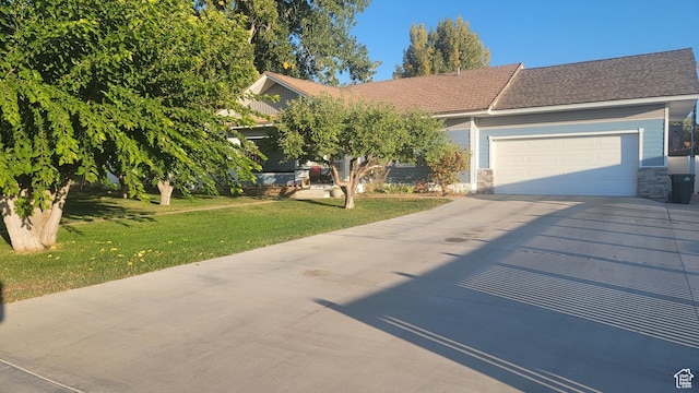 596 W 200 S, Vernal, UT 84078 - view of property hidden behind natural elements with a front lawn, concrete driveway, stone siding, and an attached garage