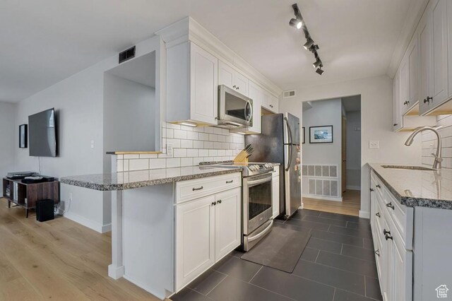 521 E 5th Ave Unit 206, Salt Lake City, UT 84103 - kitchen featuring visible vents, light stone countertops, stainless steel appliances, and a sink