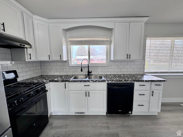kitchen featuring under cabinet range hood, white cabinetry, a sink, light wood-type flooring, and black appliances