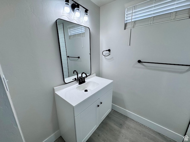 bathroom with vanity, baseboards, and wood finished floors