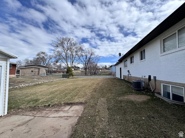 view of yard featuring fence and central AC