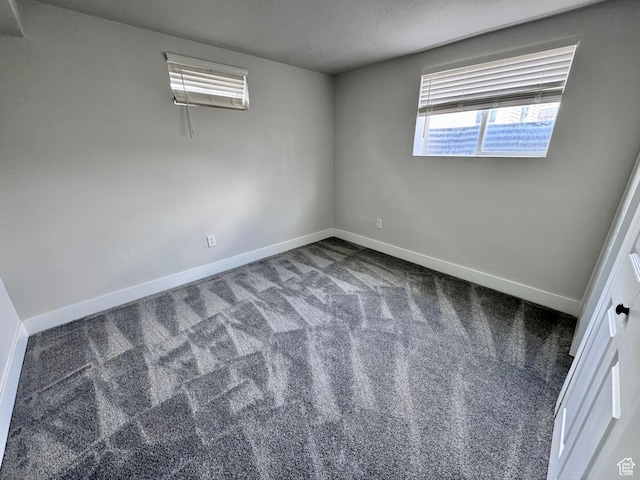 carpeted spare room featuring baseboards