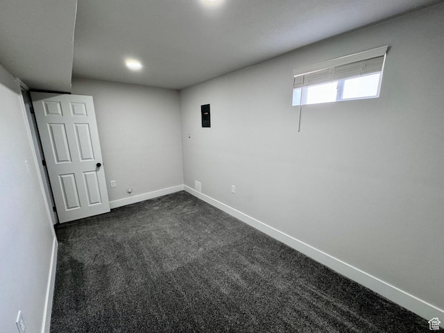 below grade area featuring baseboards and dark colored carpet