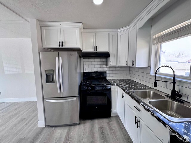 kitchen with black range with gas stovetop, a sink, stainless steel fridge with ice dispenser, white cabinetry, and under cabinet range hood