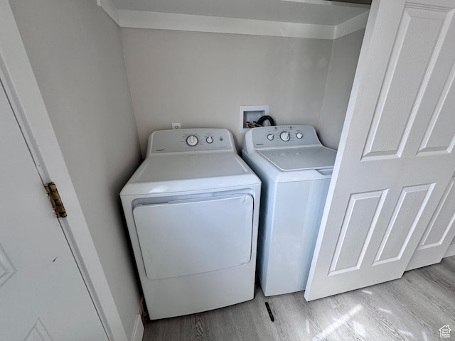 washroom featuring separate washer and dryer, wood finished floors, and laundry area