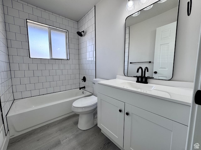 bathroom featuring toilet, vanity, shower / bathtub combination, and wood finished floors