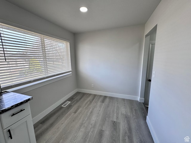 unfurnished room with wood finished floors, baseboards, and visible vents