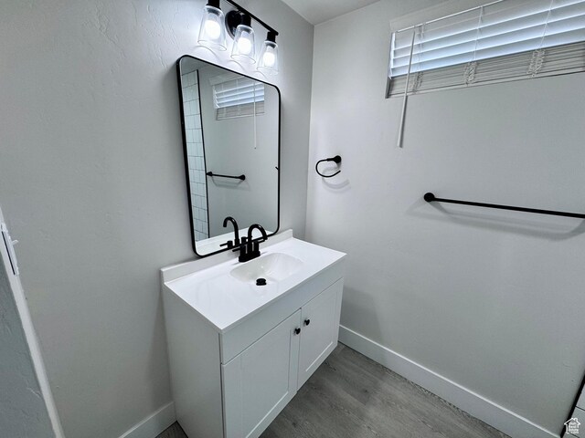 bathroom featuring baseboards, wood finished floors, and vanity