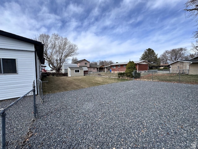 view of yard with a residential view, an outdoor structure, and fence