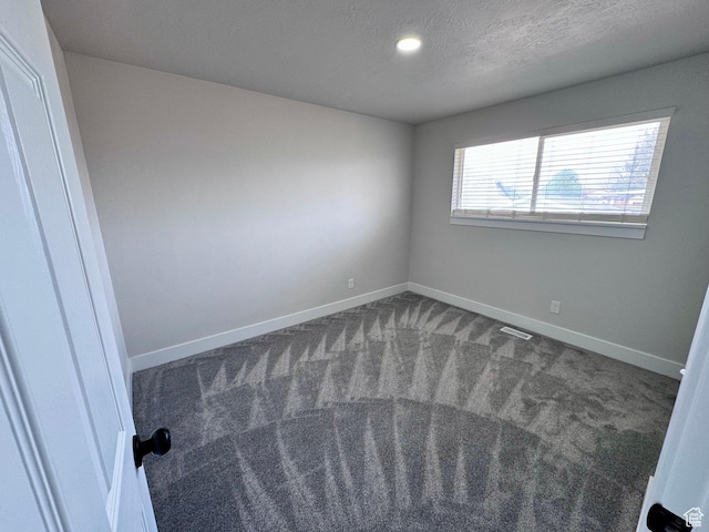 unfurnished bedroom featuring carpet, baseboards, a textured ceiling, and visible vents