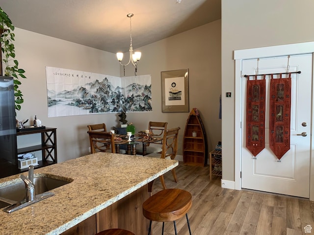 1128 S 820 E Unit 7304, Heber City, UT 84032 - kitchen featuring a breakfast bar, vaulted ceiling, light stone counters, light wood-style flooring, and a sink