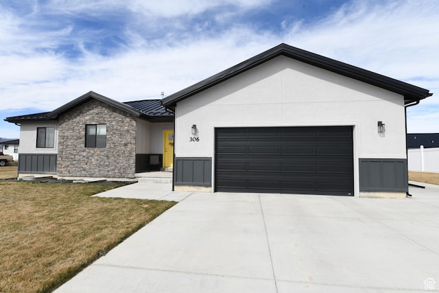 306 W 450 S, Ephraim, UT 84627 - view of front facade with stone siding, a standing seam roof, a front lawn, a garage, and driveway