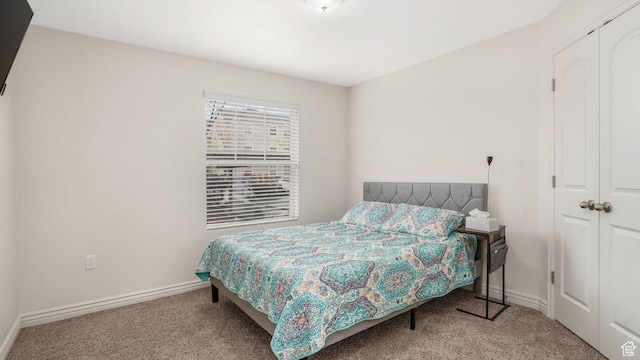 bedroom with a closet, baseboards, and carpet