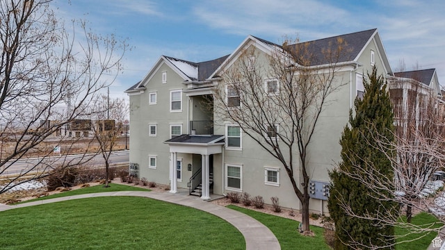 view of front of home featuring stucco siding and a front yard