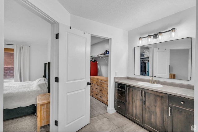 3231 S 300 W, Washington, UT 84780 - full bathroom featuring tile patterned floors, a walk in closet, vanity, and a textured ceiling