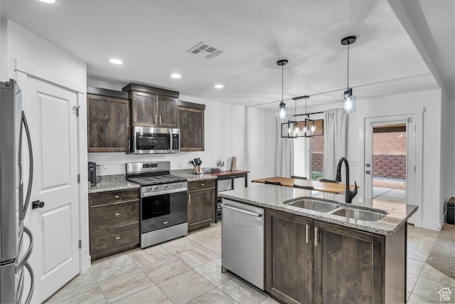 3231 S 300 W, Washington, UT 84780 - kitchen featuring dark brown cabinetry, visible vents, appliances with stainless steel finishes, a sink, and a center island with sink