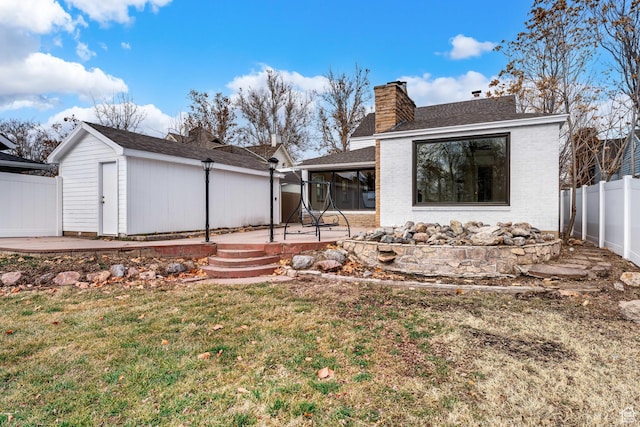 130 E 200 S, Provo, UT 84606 - back of house with a yard, a fenced backyard, a chimney, a patio area, and brick siding