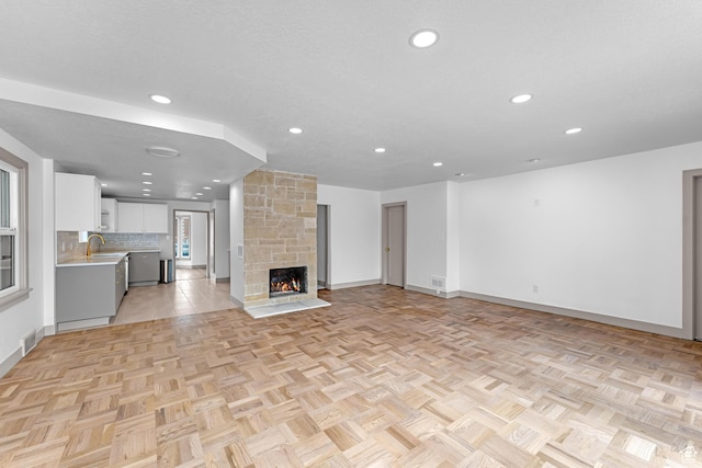 130 E 200 S, Provo, UT 84606 - unfurnished living room with visible vents, recessed lighting, a fireplace, a sink, and a textured ceiling