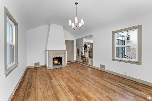 130 E 200 S, Provo, UT 84606 - unfurnished living room with visible vents, baseboards, a chandelier, vaulted ceiling, and hardwood / wood-style flooring