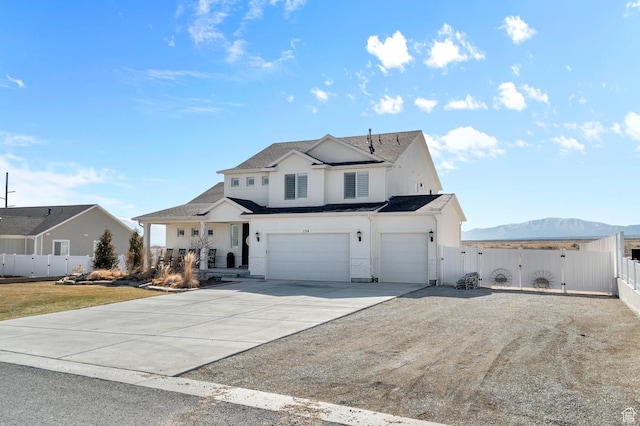 134 E Marciano Way, Grantsville, UT 84029 - view of front facade featuring a gate, fence, a mountain view, concrete driveway, and stucco siding