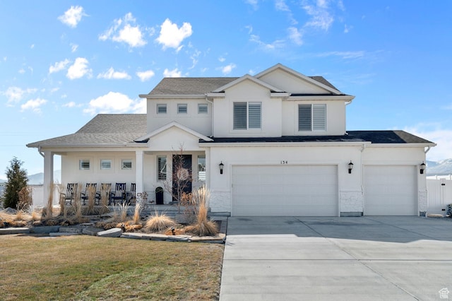 view of front of property with stucco siding, concrete driveway, an attached garage, a front yard, and a garage