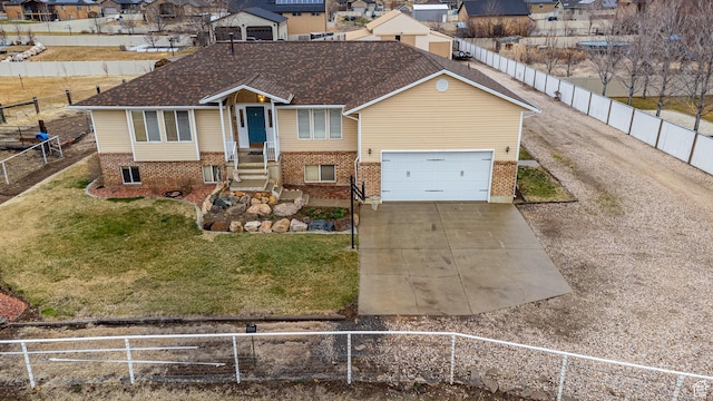 view of front of home featuring a garage, brick siding, fence private yard, and driveway