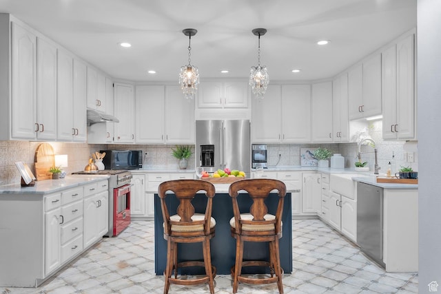 kitchen with a sink, stainless steel appliances, light floors, and light countertops