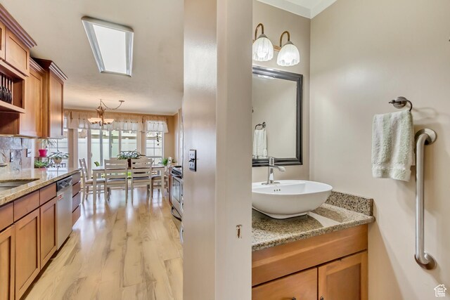 203 W Pheasantbrook Dr N, Centerville, UT 84014 - bathroom featuring decorative backsplash, a notable chandelier, wood finished floors, and vanity