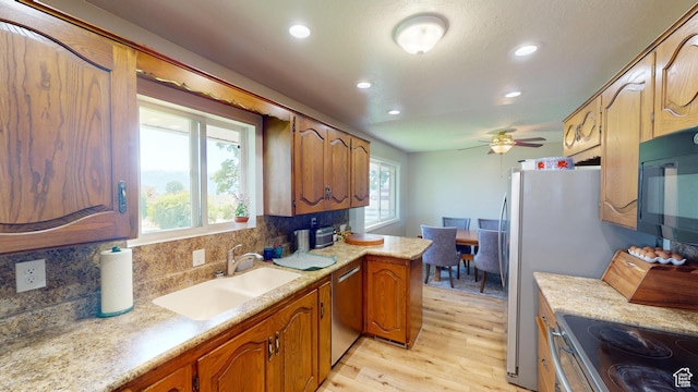 1207 S 600 W, Preston, ID 83263 - kitchen with light wood-style flooring, stainless steel appliances, recessed lighting, backsplash, and light countertops