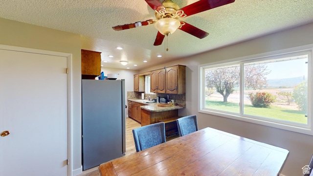 1207 S 600 W, Preston, ID 83263 - kitchen with freestanding refrigerator, brown cabinetry, a textured ceiling, ceiling fan, and recessed lighting