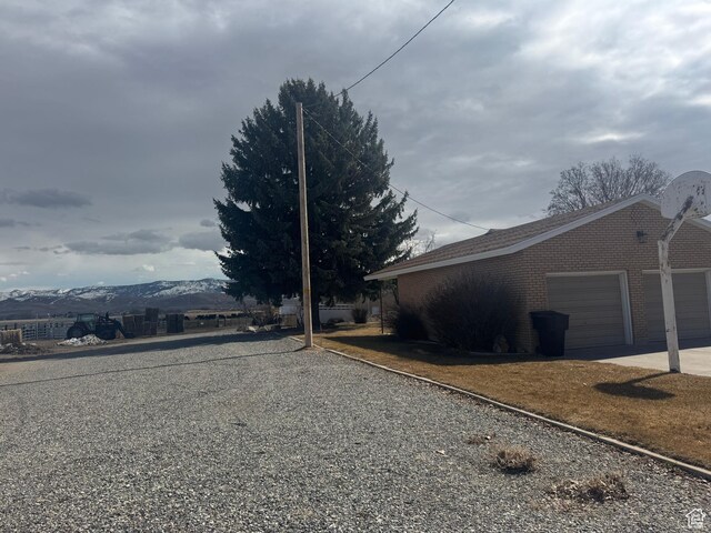 1207 S 600 W, Preston, ID 83263 - view of side of home with a garage, driveway, and brick siding