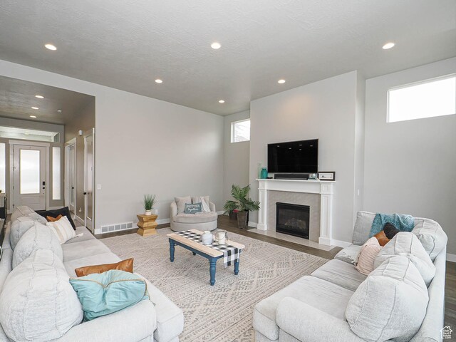 living area featuring wood finished floors, recessed lighting, visible vents, and a textured ceiling