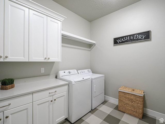 washroom with a textured ceiling, cabinet space, baseboards, light floors, and washing machine and clothes dryer