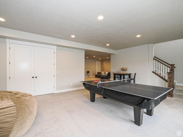 rec room featuring visible vents, a textured ceiling, recessed lighting, baseboards, and light colored carpet