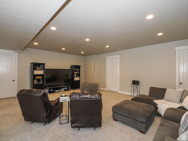 living area featuring recessed lighting, light carpet, and a textured ceiling