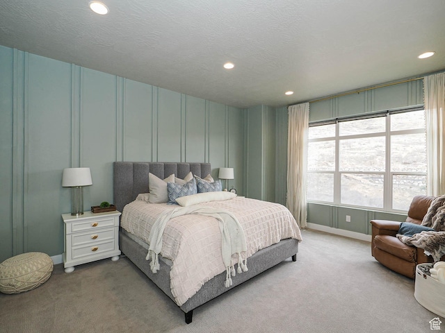 carpeted bedroom with recessed lighting, a textured ceiling, and baseboards