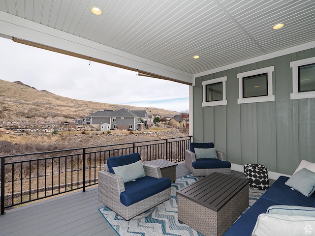 wooden terrace with a mountain view, a residential view, and outdoor lounge area