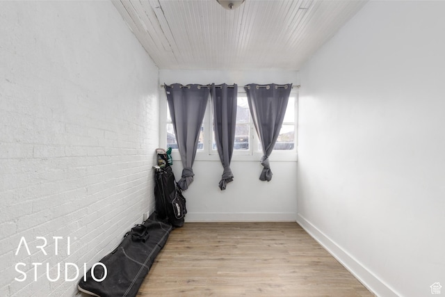 2516 S Orchard Ave, Ogden, UT 84401 - empty room featuring light wood-style flooring, brick wall, and baseboards